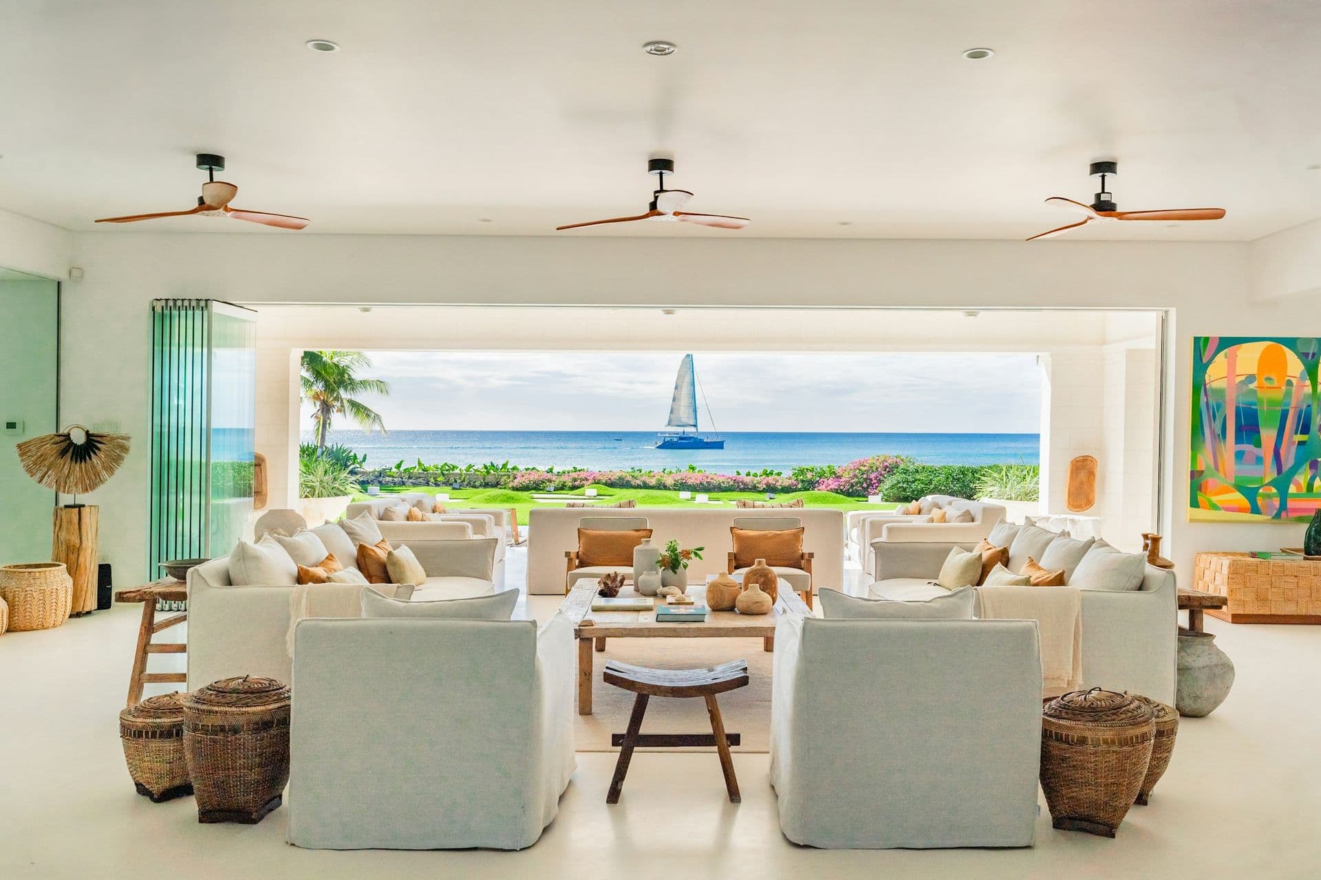Open living room framing the beach and a sailboat on the sea at Moonlight Beauty, Barbados