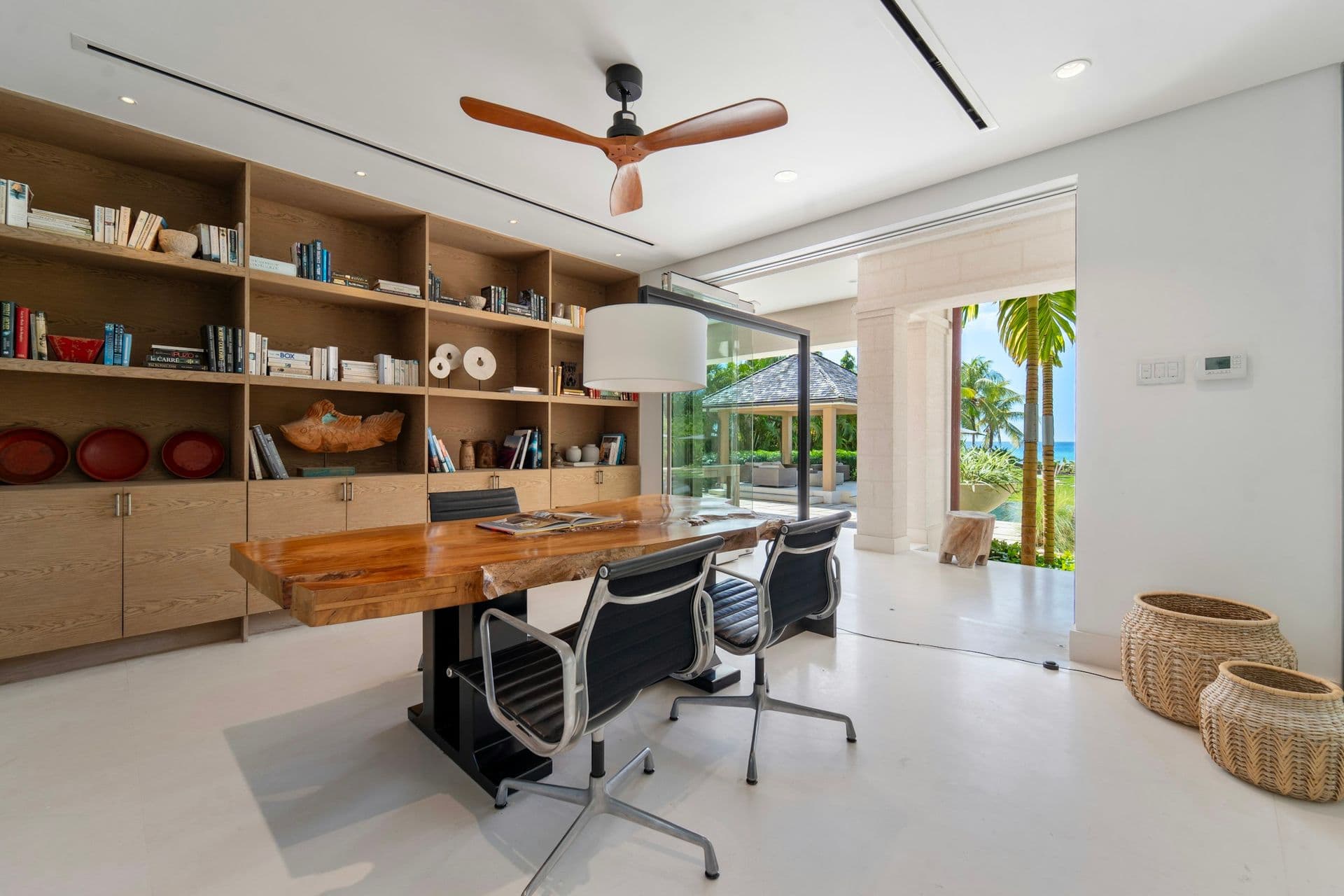 Glass-walled study with a timber desk and bookshelves at Moonlight Beauty, Barbados