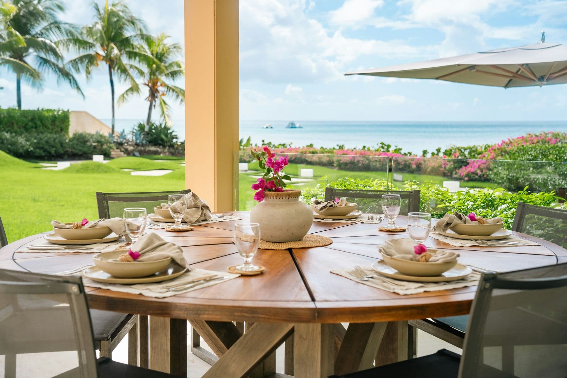 Outdoor dining table on the terrace overlooking the lawn and sea at Moonlight Beauty, Barbados