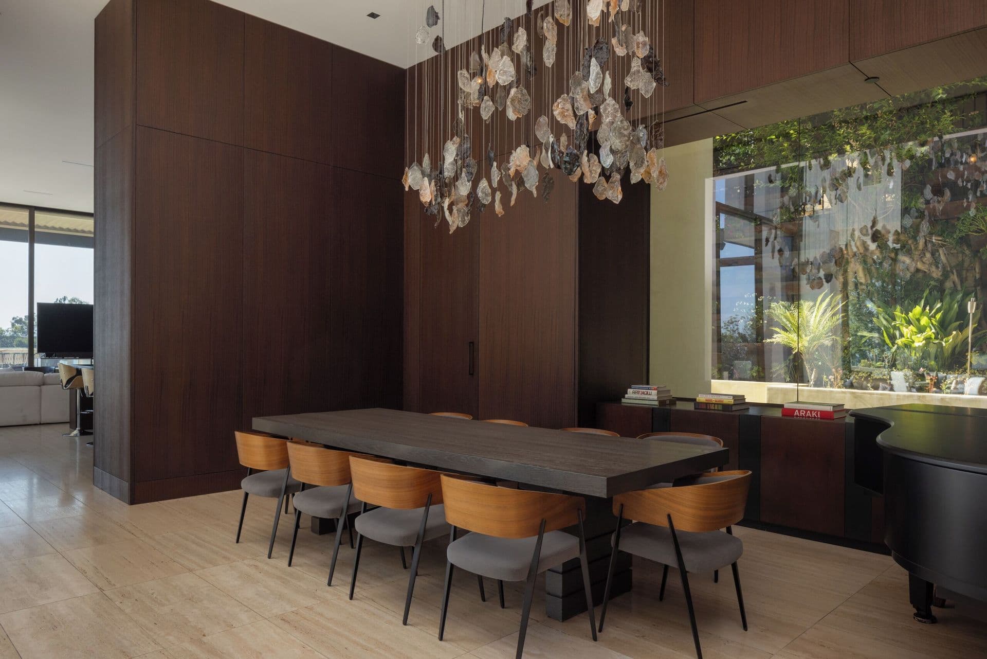 Dining room with a long wood table set for eight beneath pendant lighting