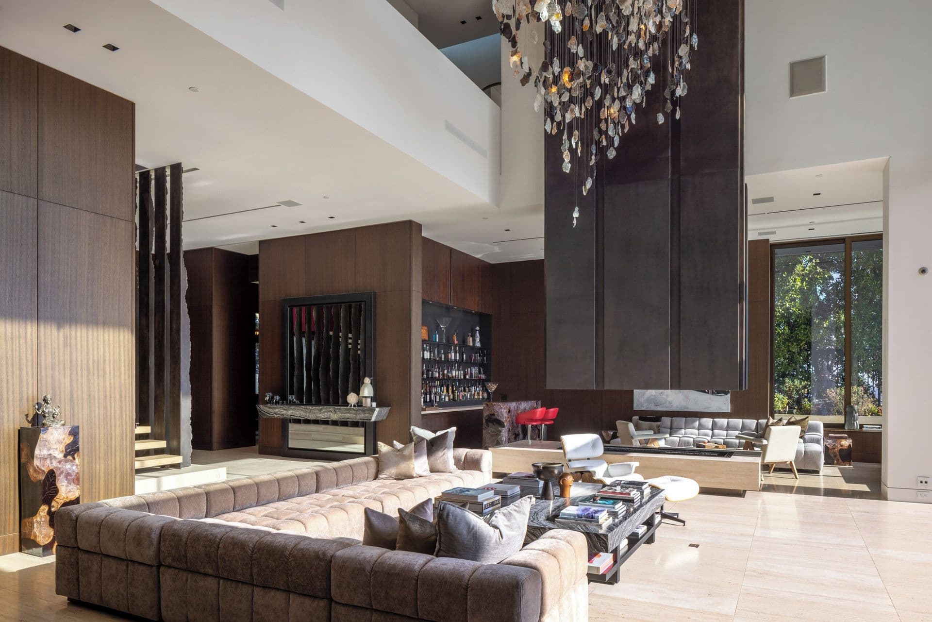 Living area with built-in bar and dark wood cabinetry beneath a sculptural chandelier