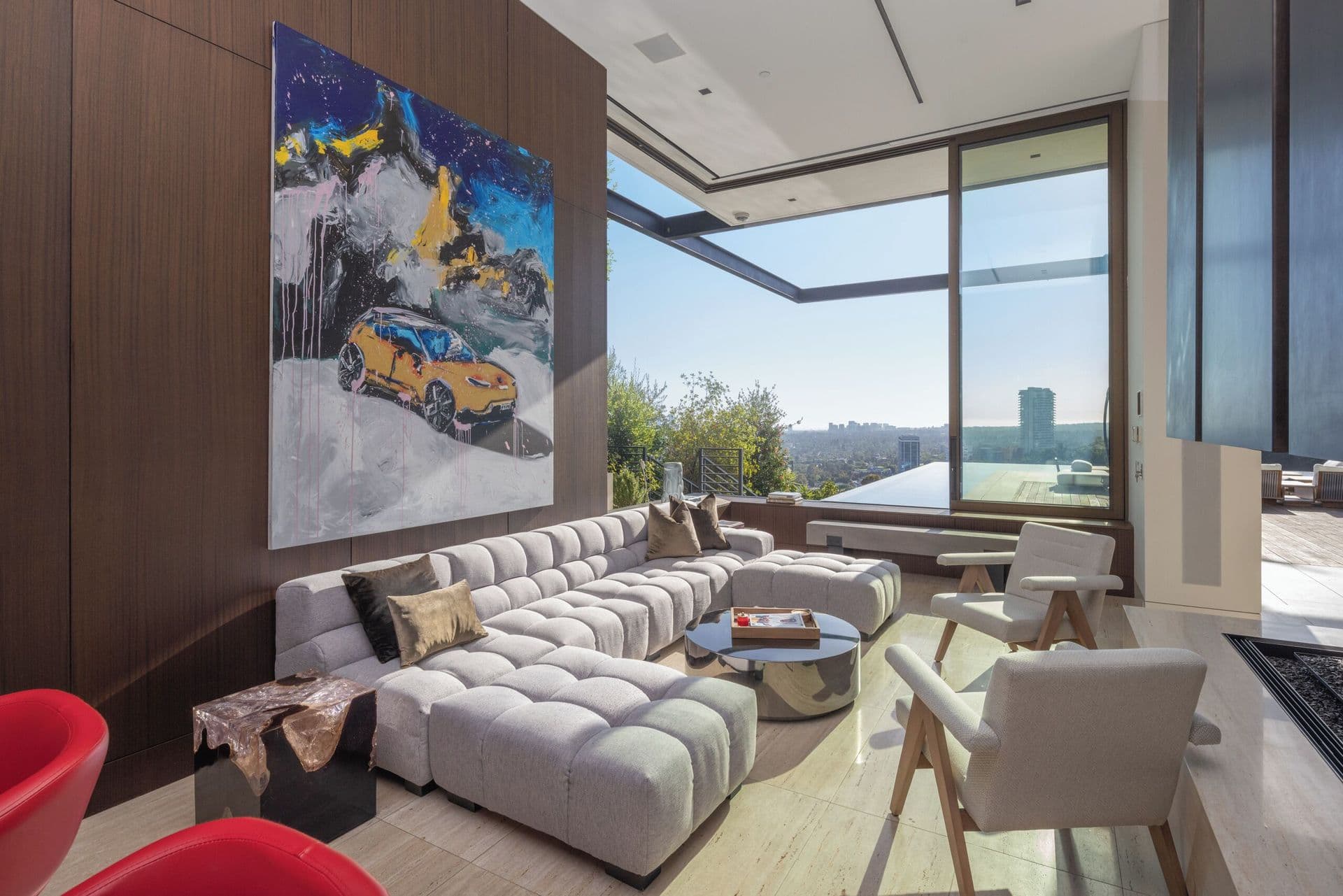 Living room with a curated art wall and statement red accent chairs