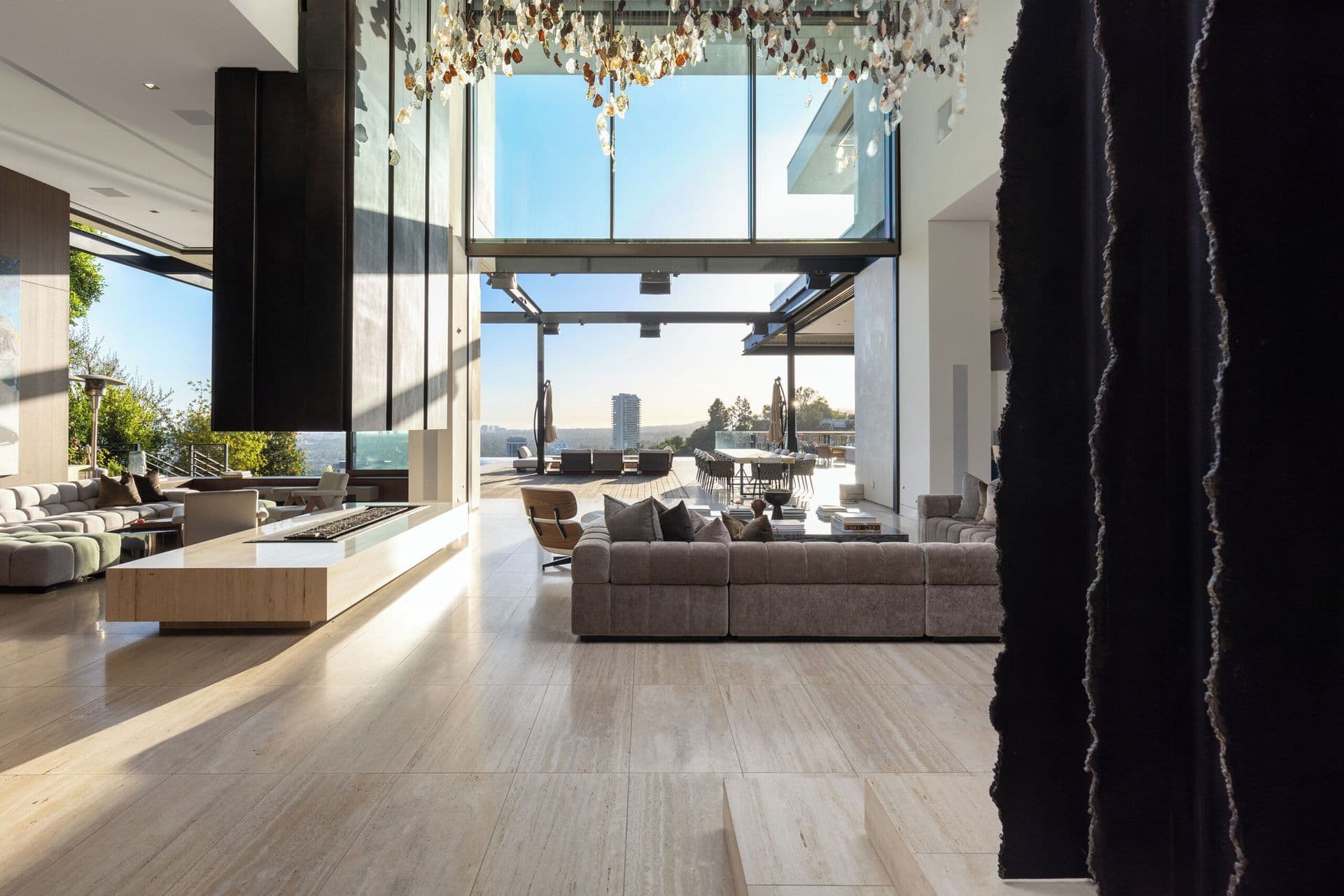 Open-plan living space flowing onto a terrace with city views beyond