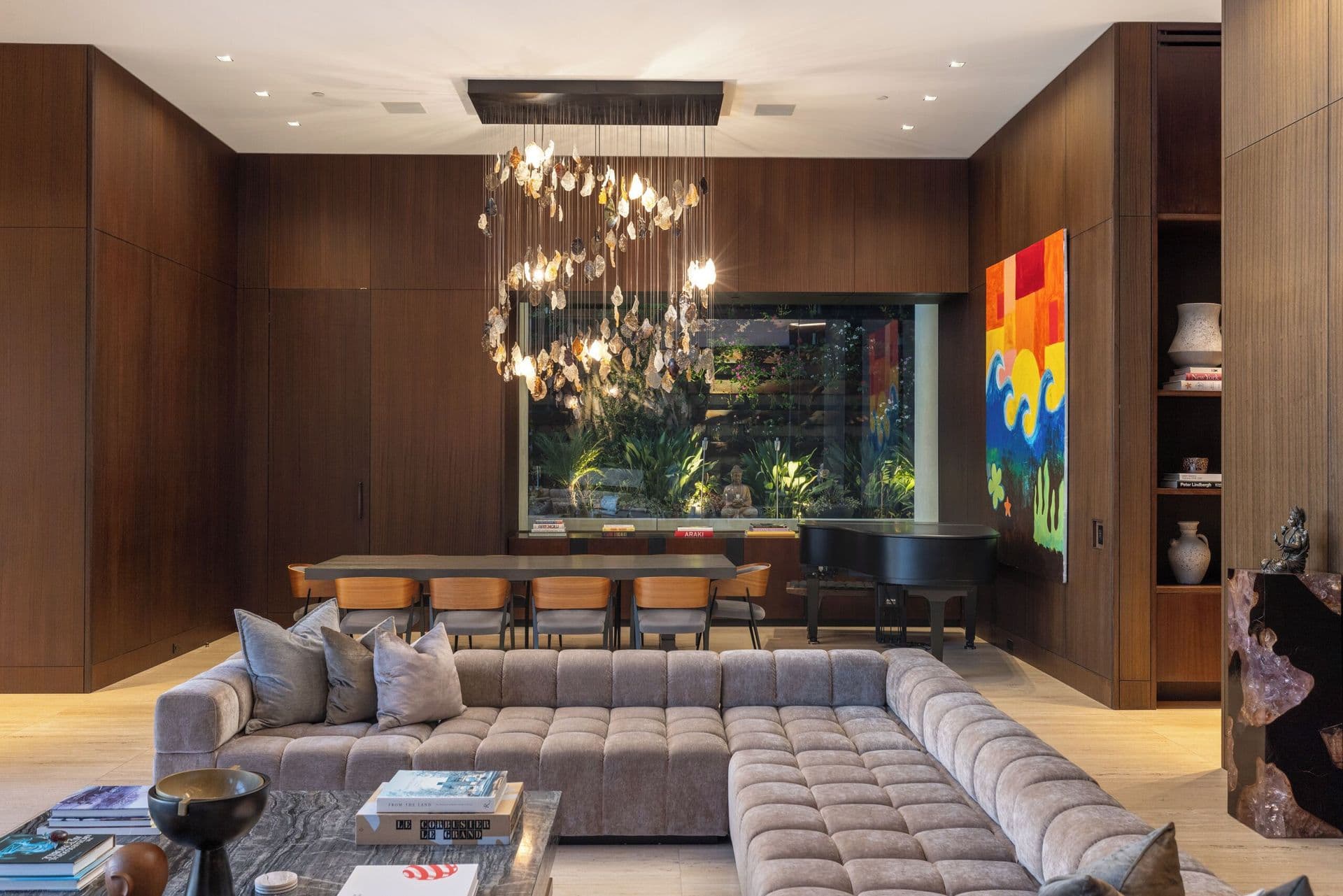 Sitting room with a grand piano, gallery art and a sculptural chandelier