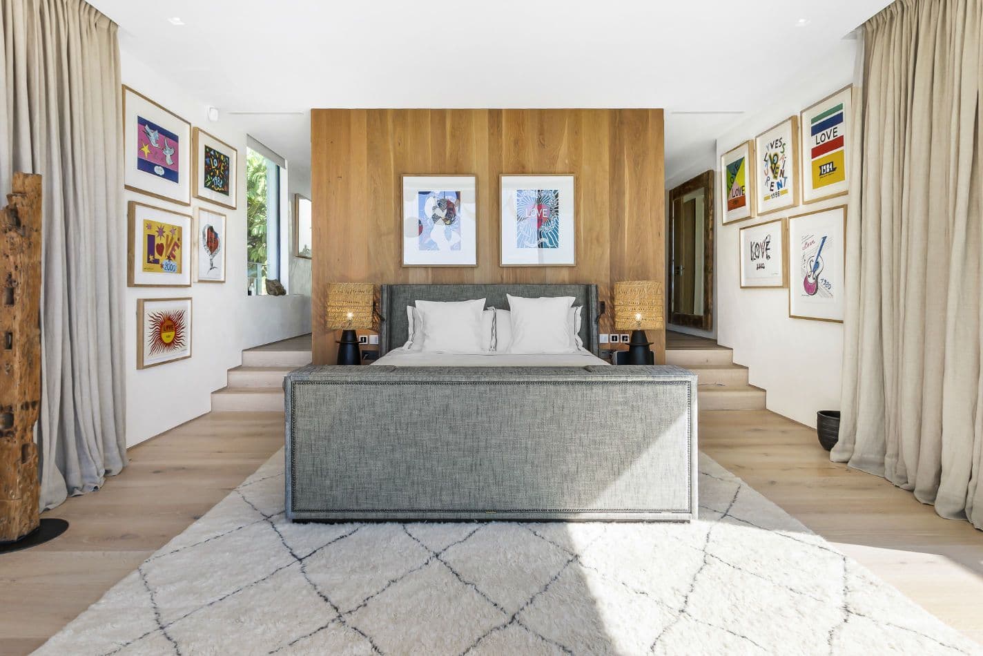 Double bedroom with a grey bed and a framed gallery wall at Aphrodite's Oasis, Ibiza