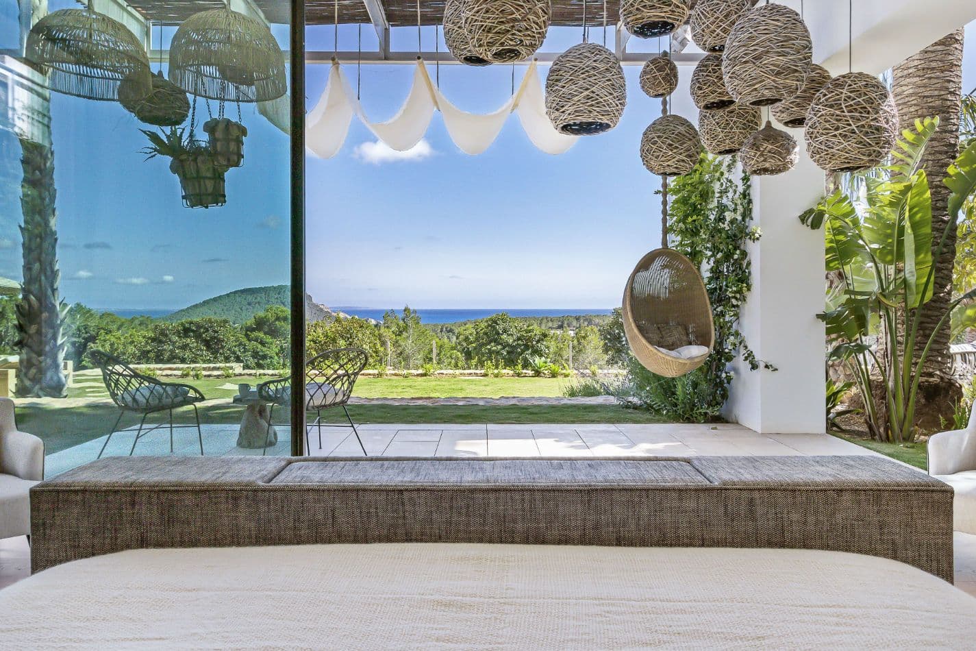 Bedroom suite with a hanging chair opening to a sea-view terrace at Aphrodite's Oasis, Ibiza