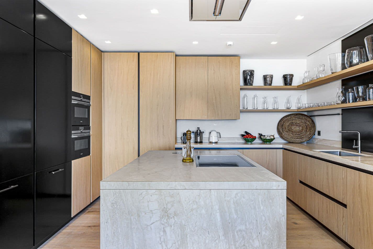 Kitchen with an oak and black-lacquer scheme and a marble island at Aphrodite's Oasis, Ibiza