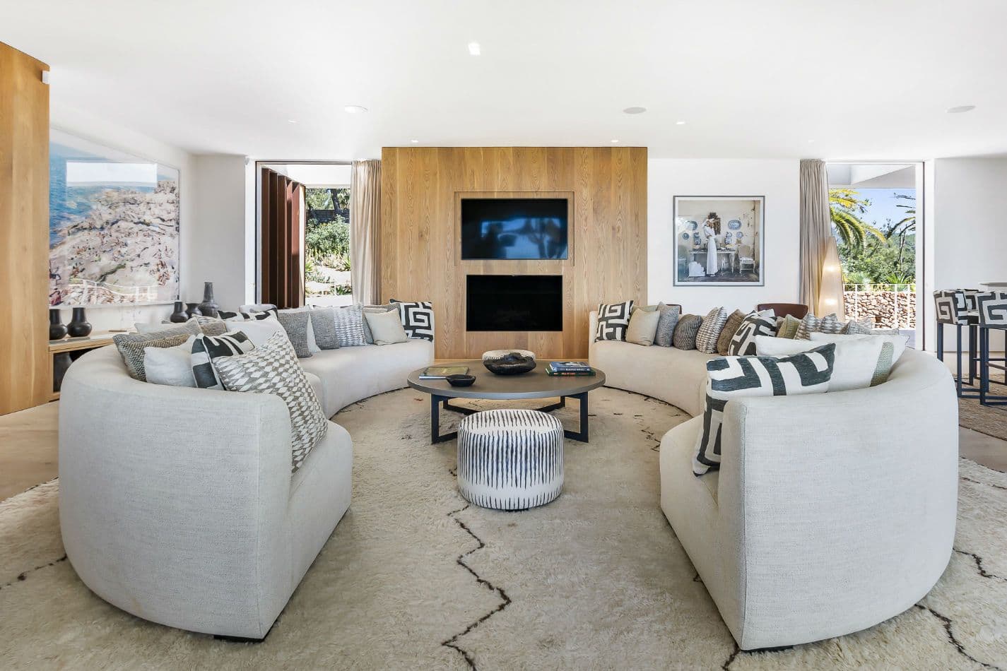 Living room with curved cream sofas, a fireplace and patterned cushions at Aphrodite's Oasis, Ibiza