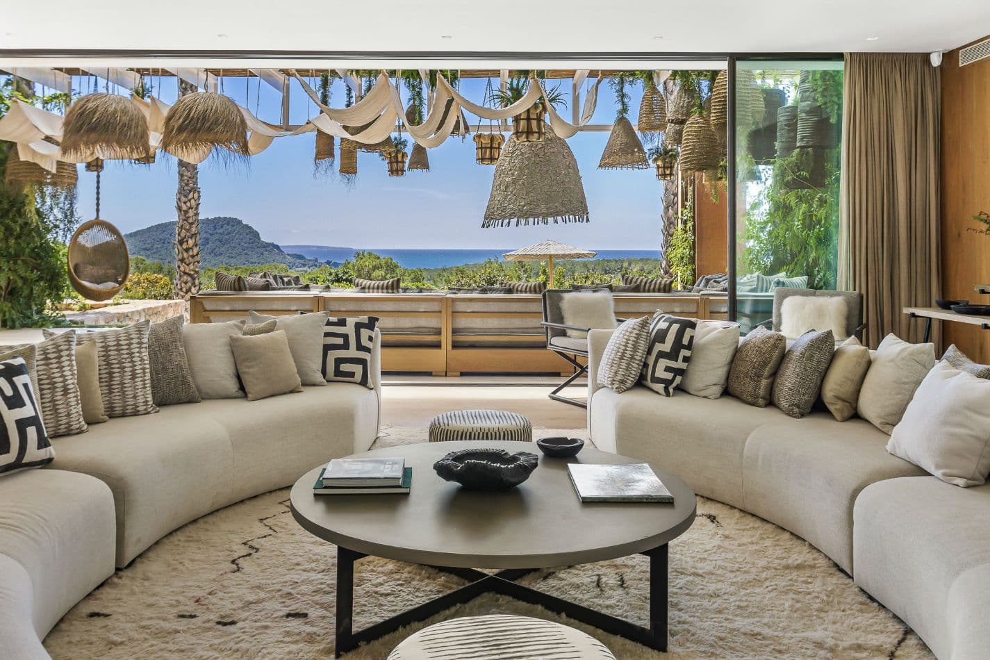 Covered terrace lounge with woven pendants and sea views at Aphrodite's Oasis, Ibiza