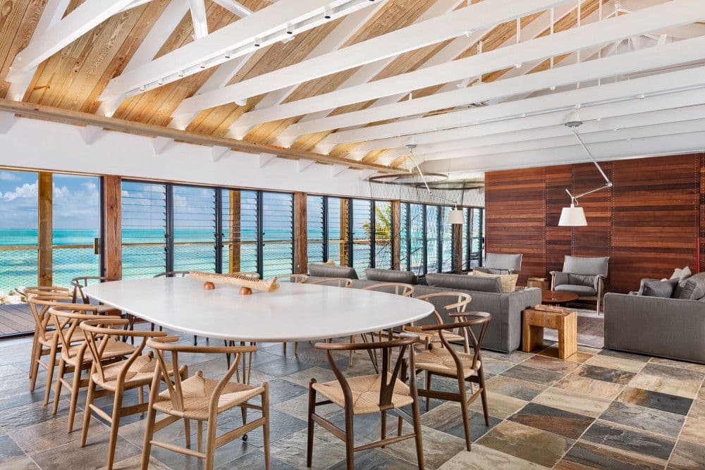 Dining area with an oval table and wishbone chairs facing the ocean at Silver Sands