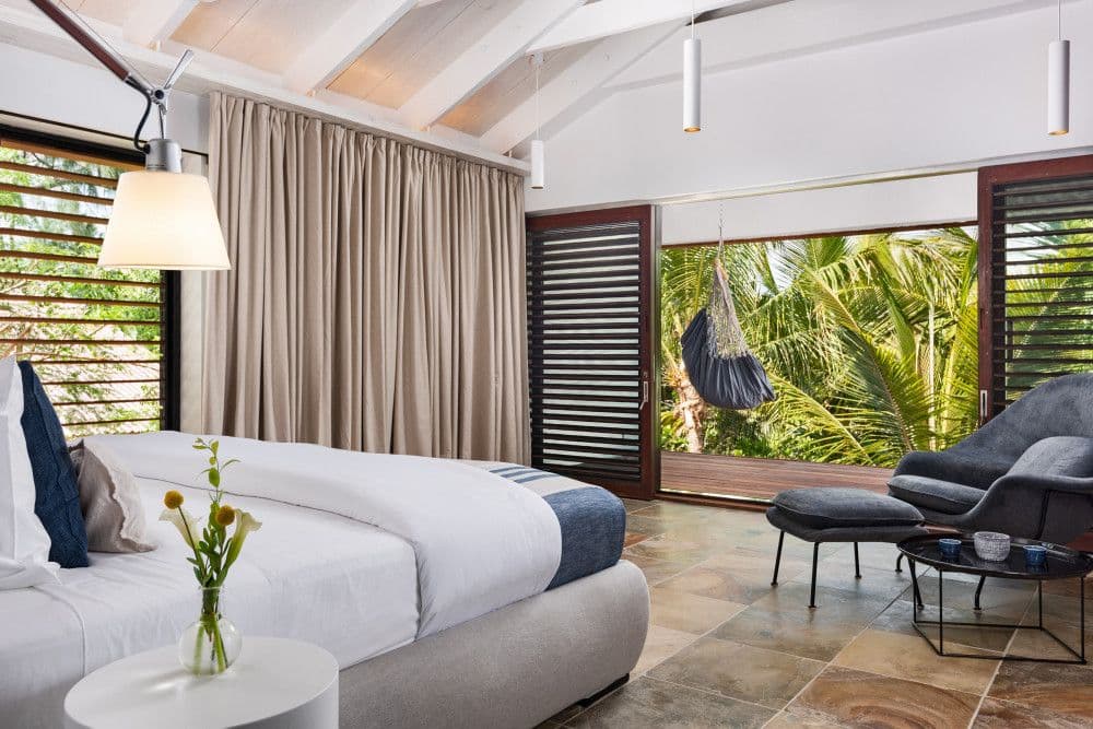 Garden-view bedroom with a terrace and hammock chair at Silver Sands
