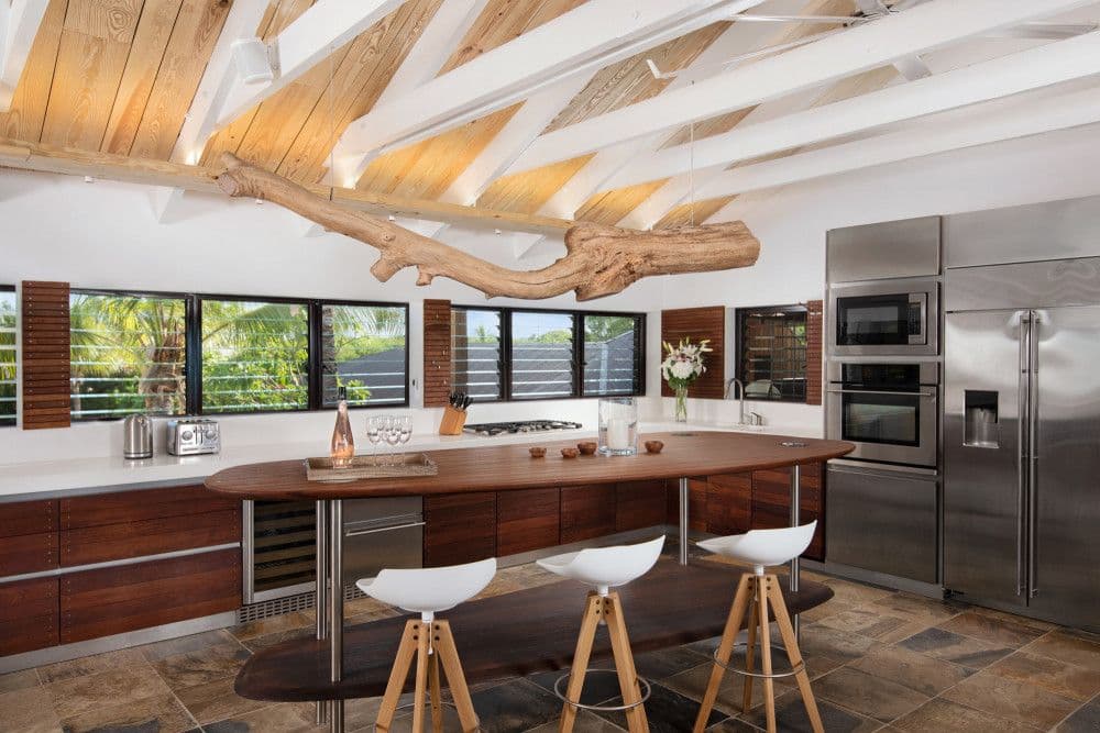 Kitchen with a curved timber island, bar seating and stainless appliances