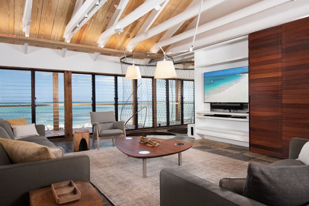 Living room with a timber-beamed ceiling and floor-to-ceiling ocean views