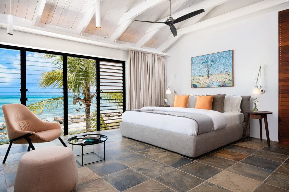 Oceanfront bedroom with glass doors to a sea-view terrace at Silver Sands