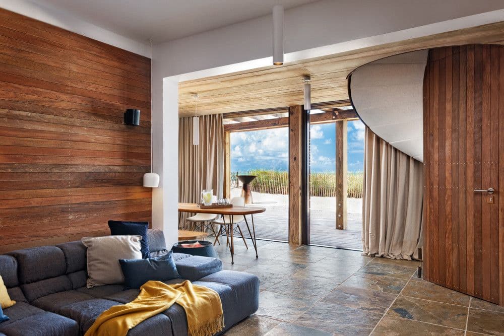 Snug lounge with a sculptural timber spiral staircase at Silver Sands