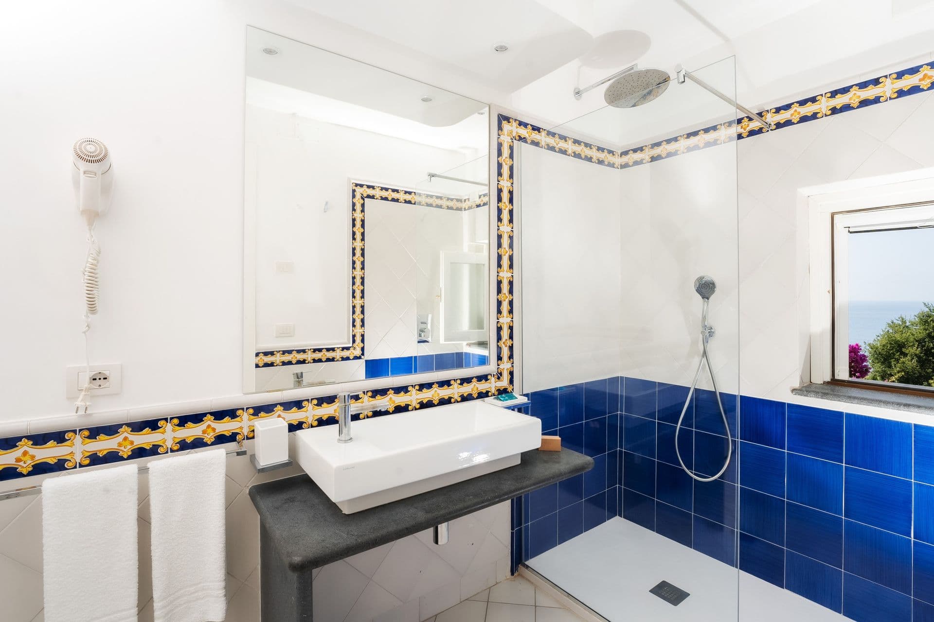 Bathroom with handpainted blue tile shower surround at Graceful Sea