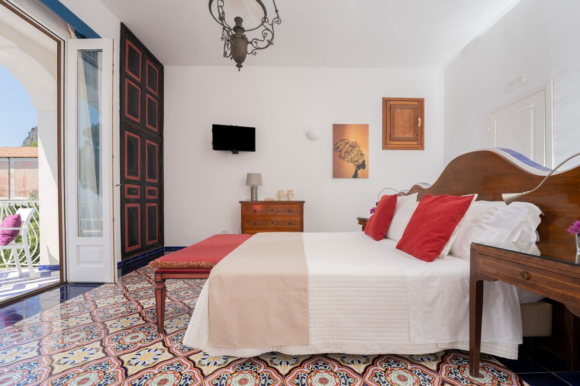 Guest bedroom with double bed, red accents and terrace access at Graceful Sea
