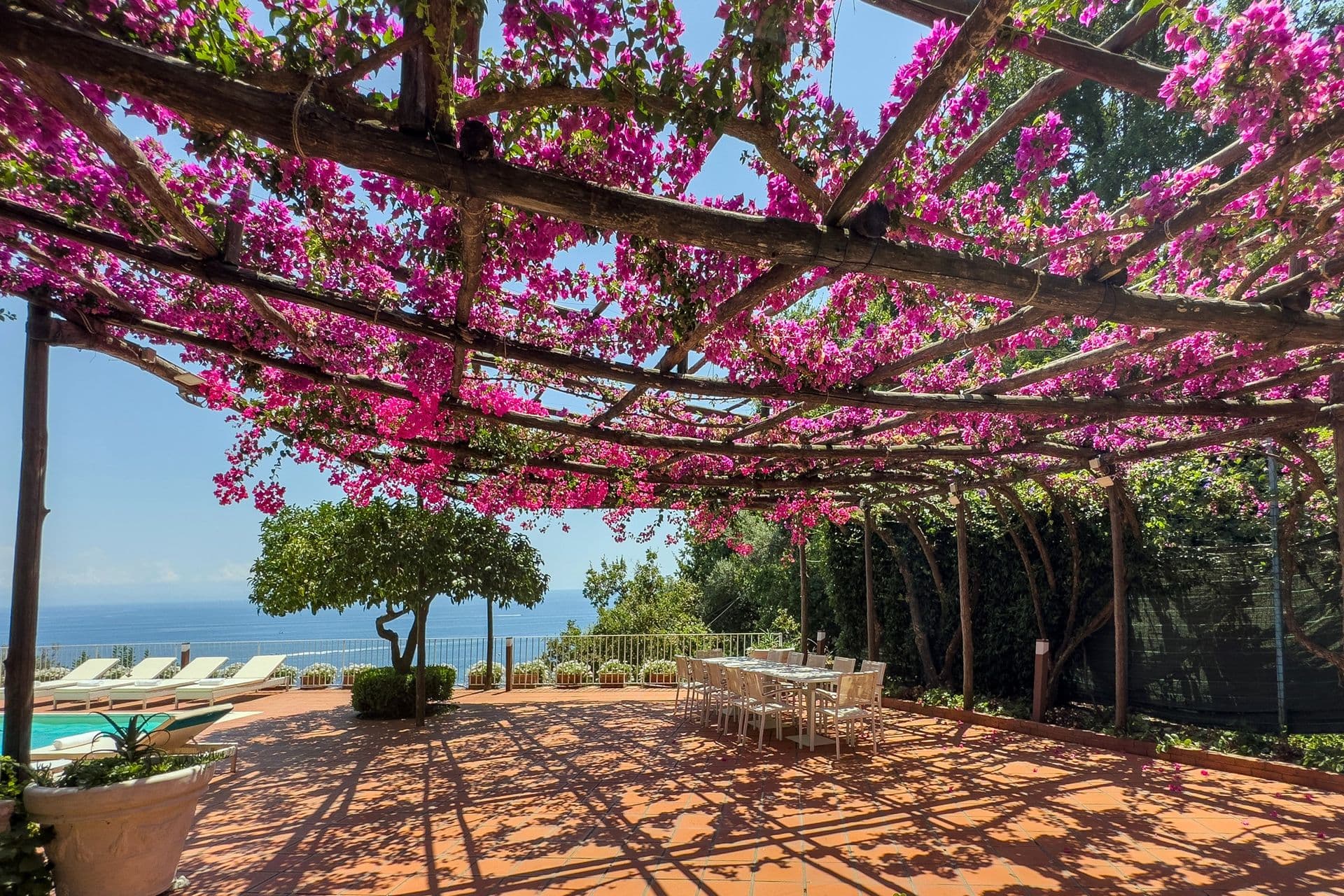 Bougainvillea-draped pergola walkway leading towards the sea view at Graceful Sea
