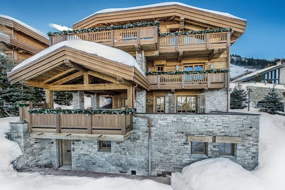 Timber and stone chalet under snow in Courchevel 1850