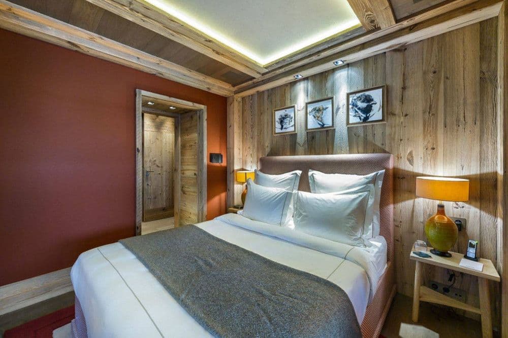 Double bedroom with a red feature wall at Courchevel 16