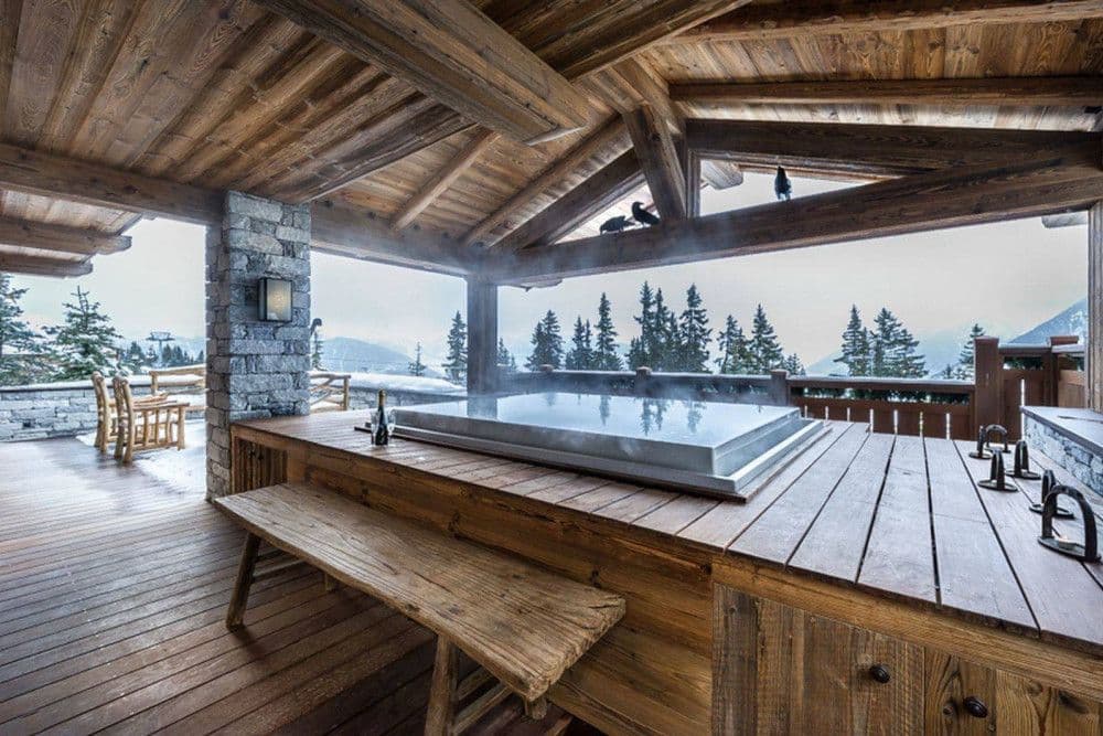 Outdoor hot tub on a timber terrace with mountain views at Courchevel 16