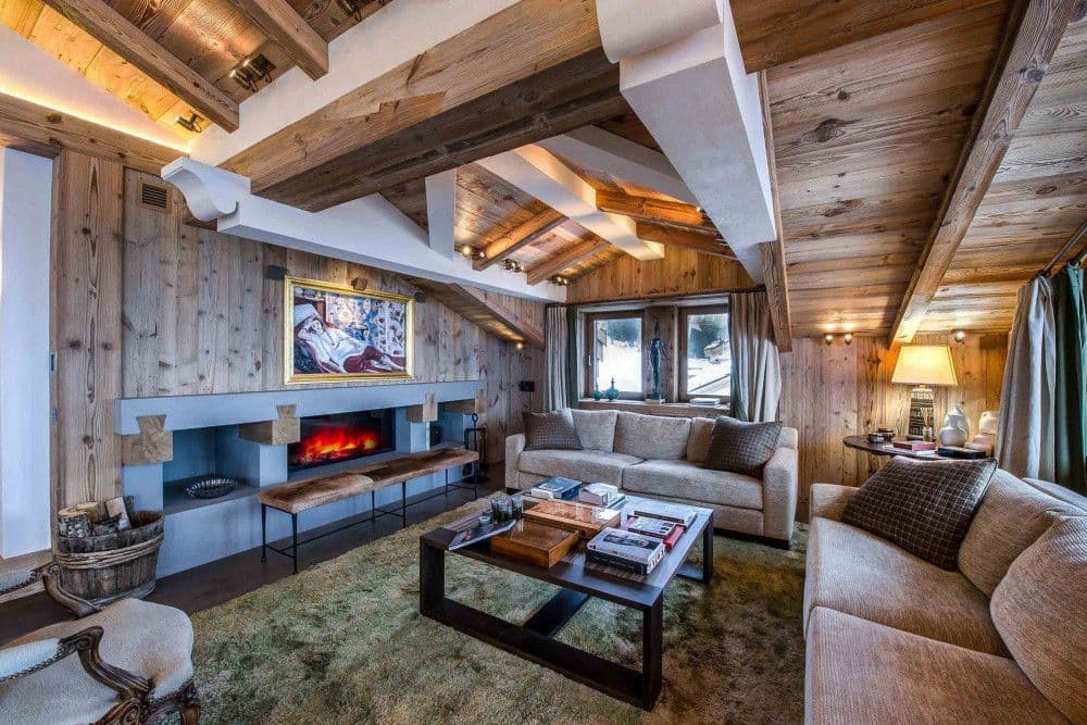 Living room with a fireplace and wood-panelled walls at Courchevel 16