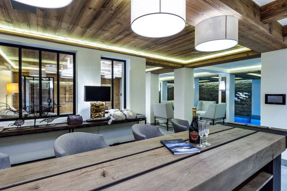 Snug lounge opening to a glazed terrace with mountain views at Courchevel 16