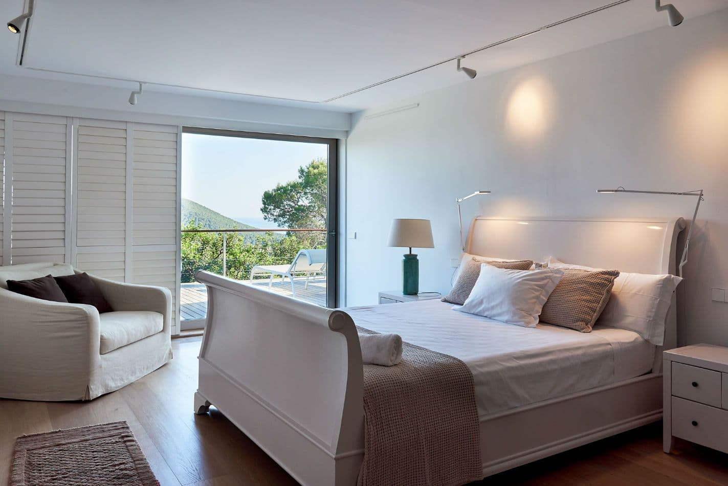 Bedroom with a white sleigh bed and teal throw at Somewhere On The Horizon