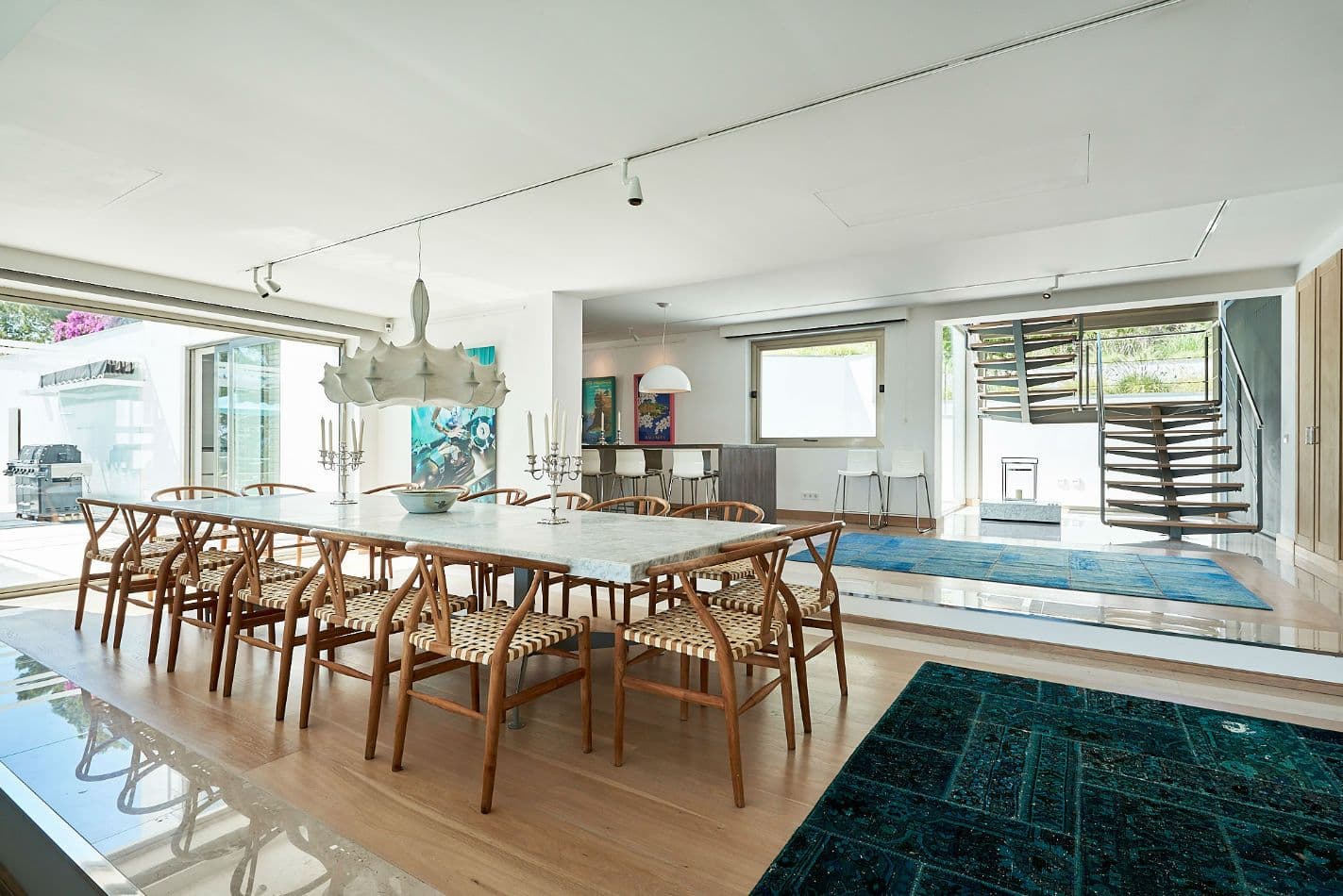 Dining table with a white marble top beneath an open staircase at Somewhere On The Horizon