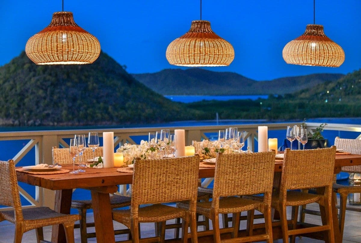 Candlelit dinner table set on the terrace at Sea Breeze Cove at dusk