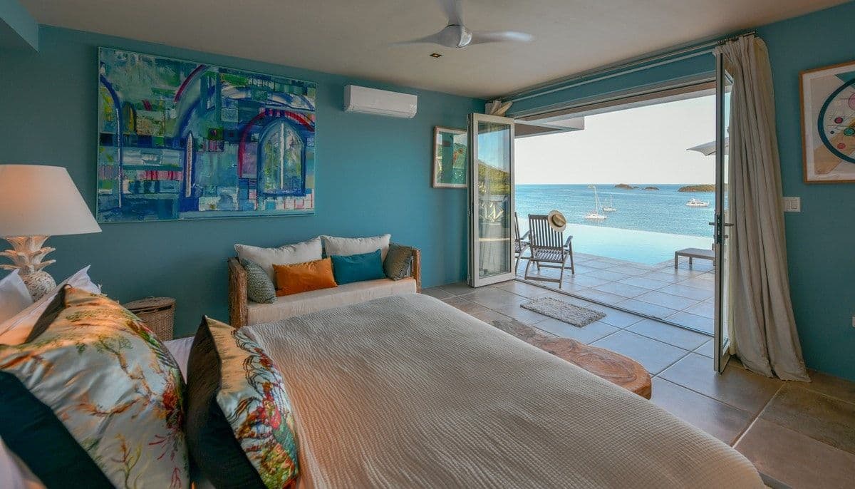 Bedroom opening directly to the pool and sea at Sea Breeze Cove