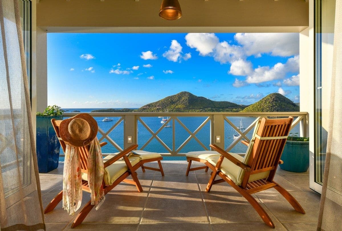 Sea Breeze Cove villa in Antigua lit at dusk above its infinity pool with sea views