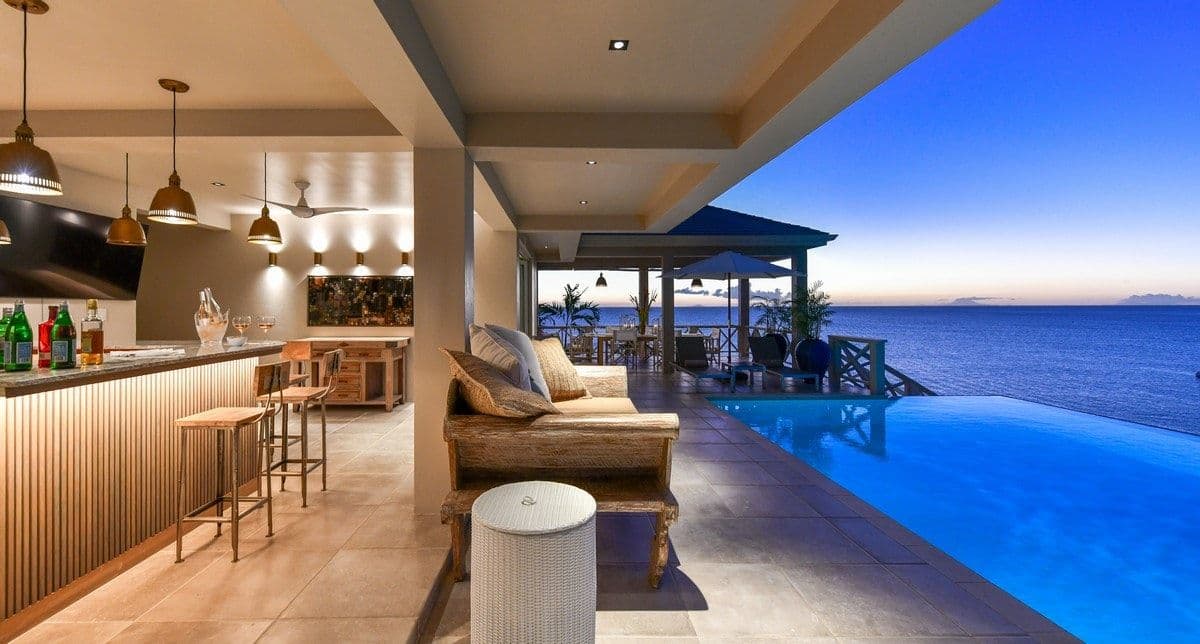 Poolside bar and seating at dusk at Sea Breeze Cove