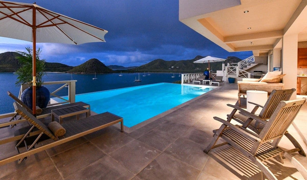 Sun loungers beside the infinity pool at Sea Breeze Cove overlooking the bay