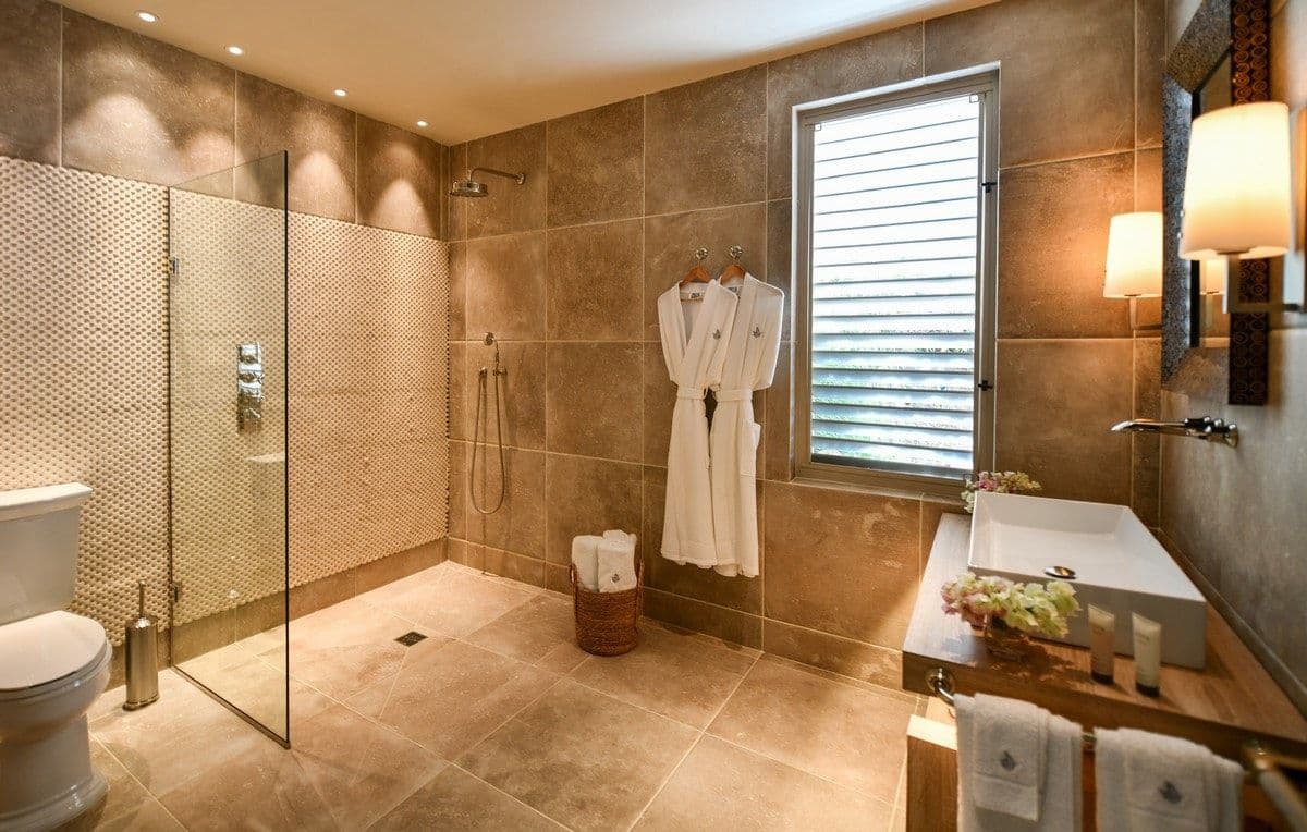 Walk-in rain shower in a stone bathroom at Sea Breeze Cove