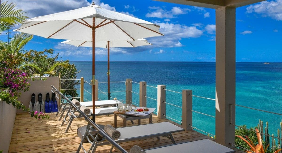 Long covered dining table on the terrace at Sea Breeze Cove with sea views