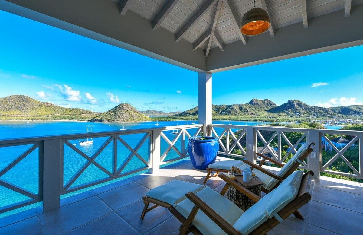 Shaded terrace with loungers and a parasol at Sea Breeze Cove framing the Caribbean Sea