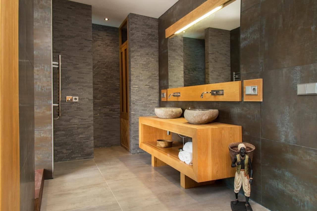 Grey stone bathroom with carved stone vessel sinks