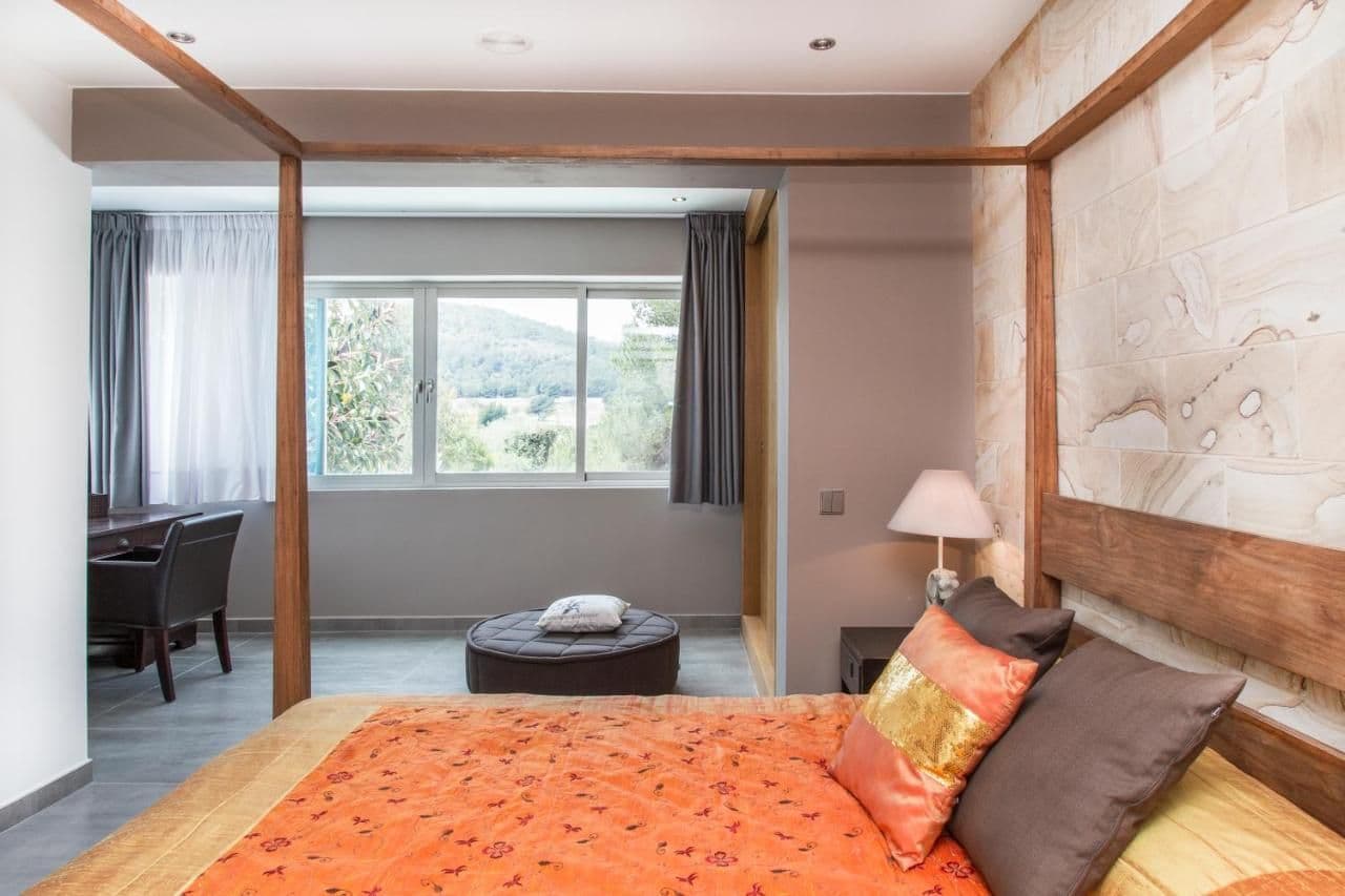 Bedroom with a stone accent wall and burnt orange cushions