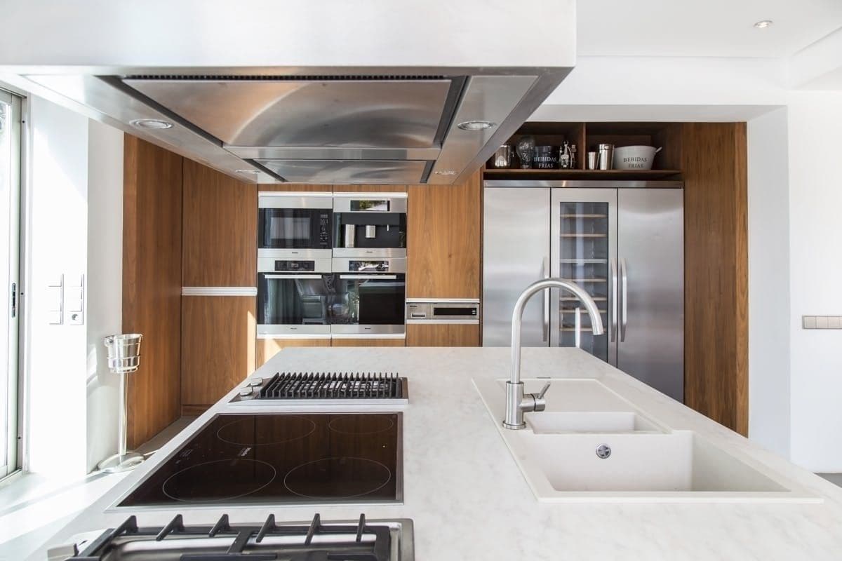 White marble kitchen island with gas hob and integrated sink