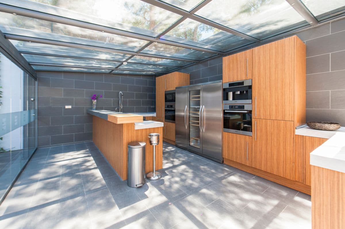 Kitchen with a full glass roof and wood cabinetry