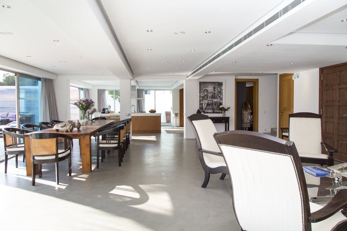 Open plan dining and lounge area with white armchairs