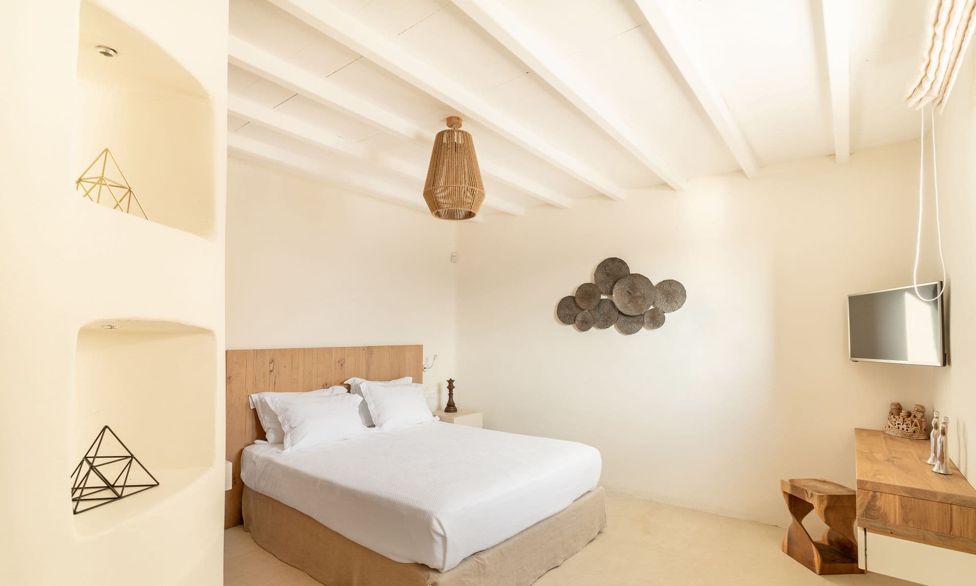 Bedroom with white double bed, wooden nightstands and decorative wall art