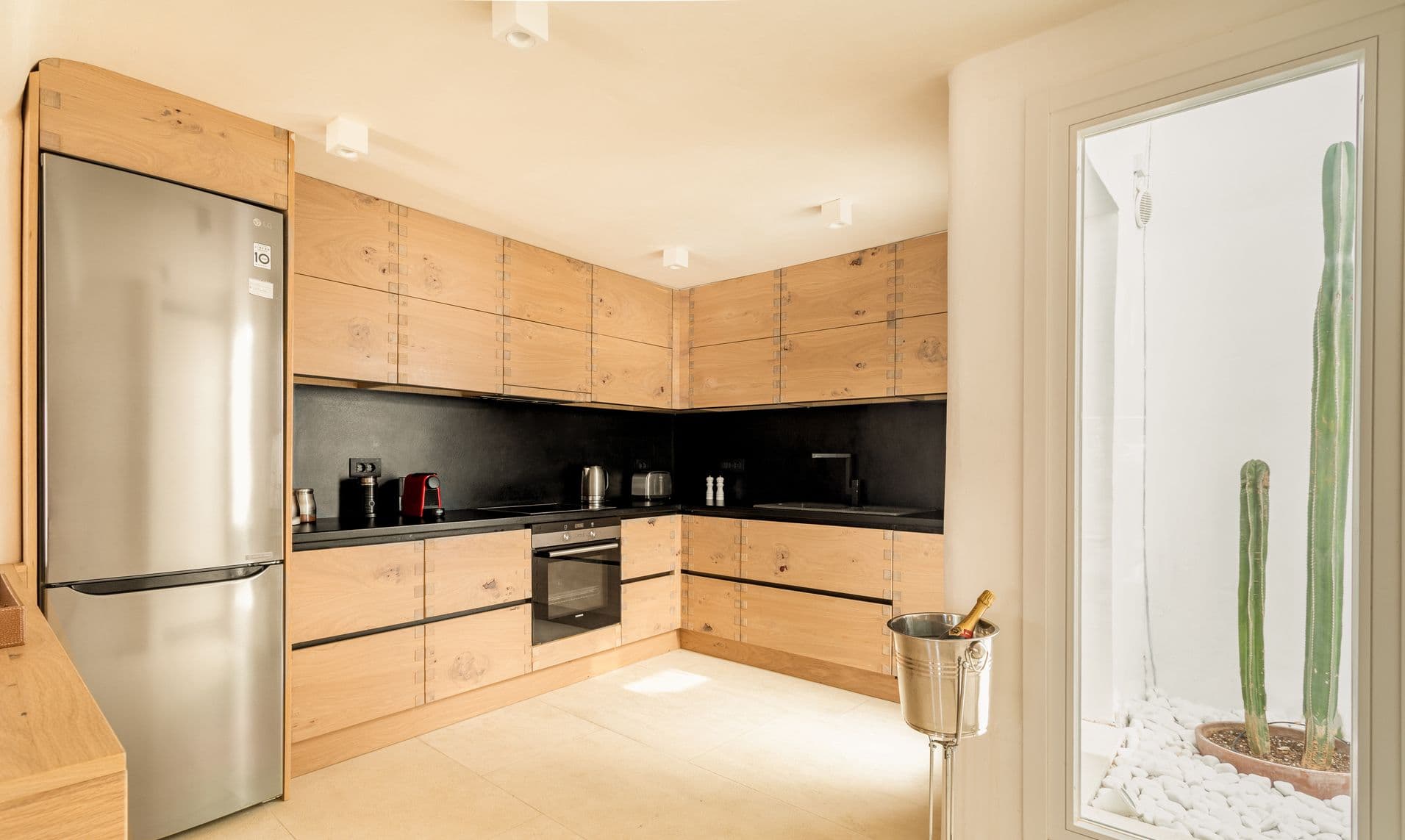 Modern wood and black kitchen with island seating and integrated appliances