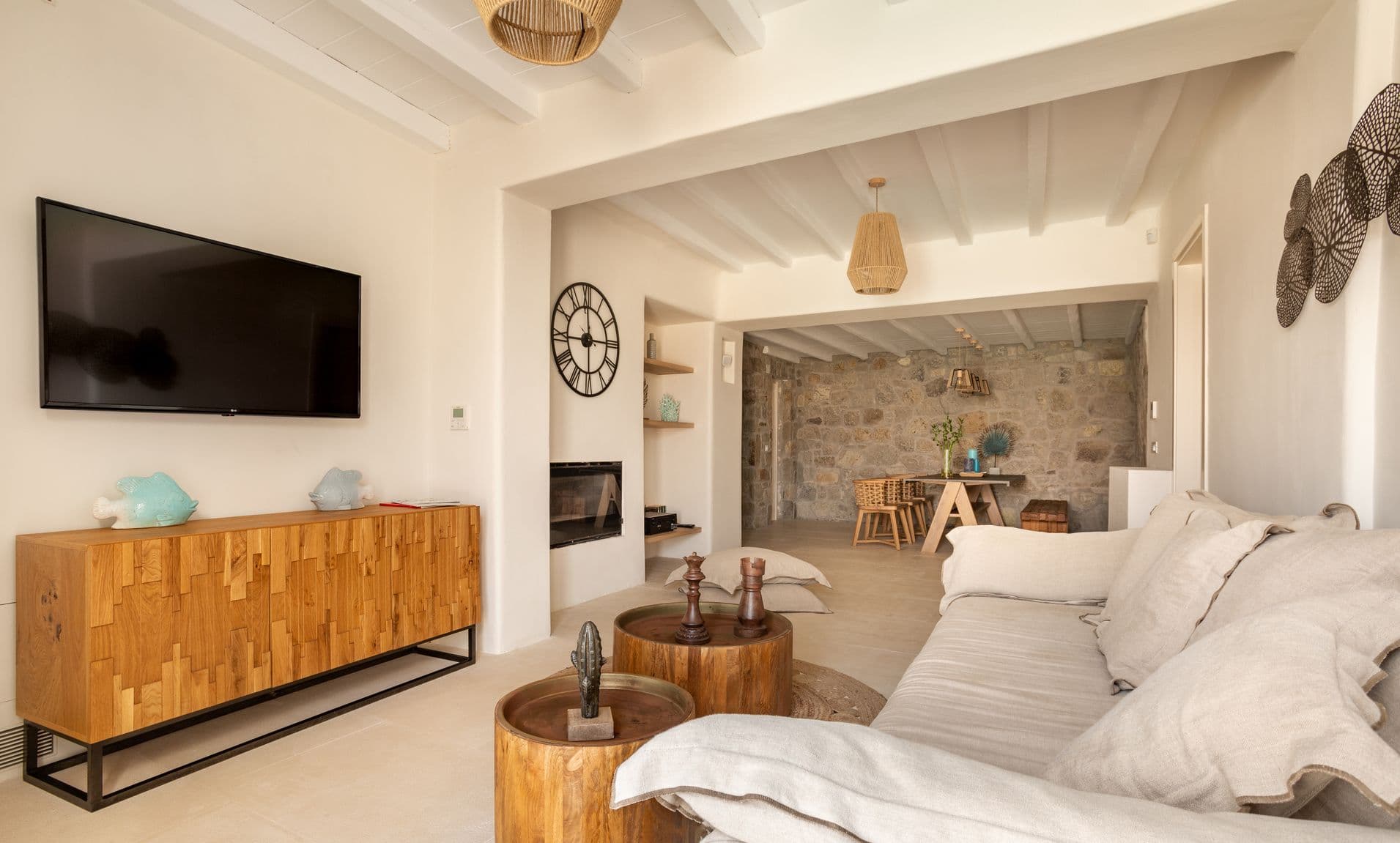 Second living room with rustic stone wall and wall-mounted television