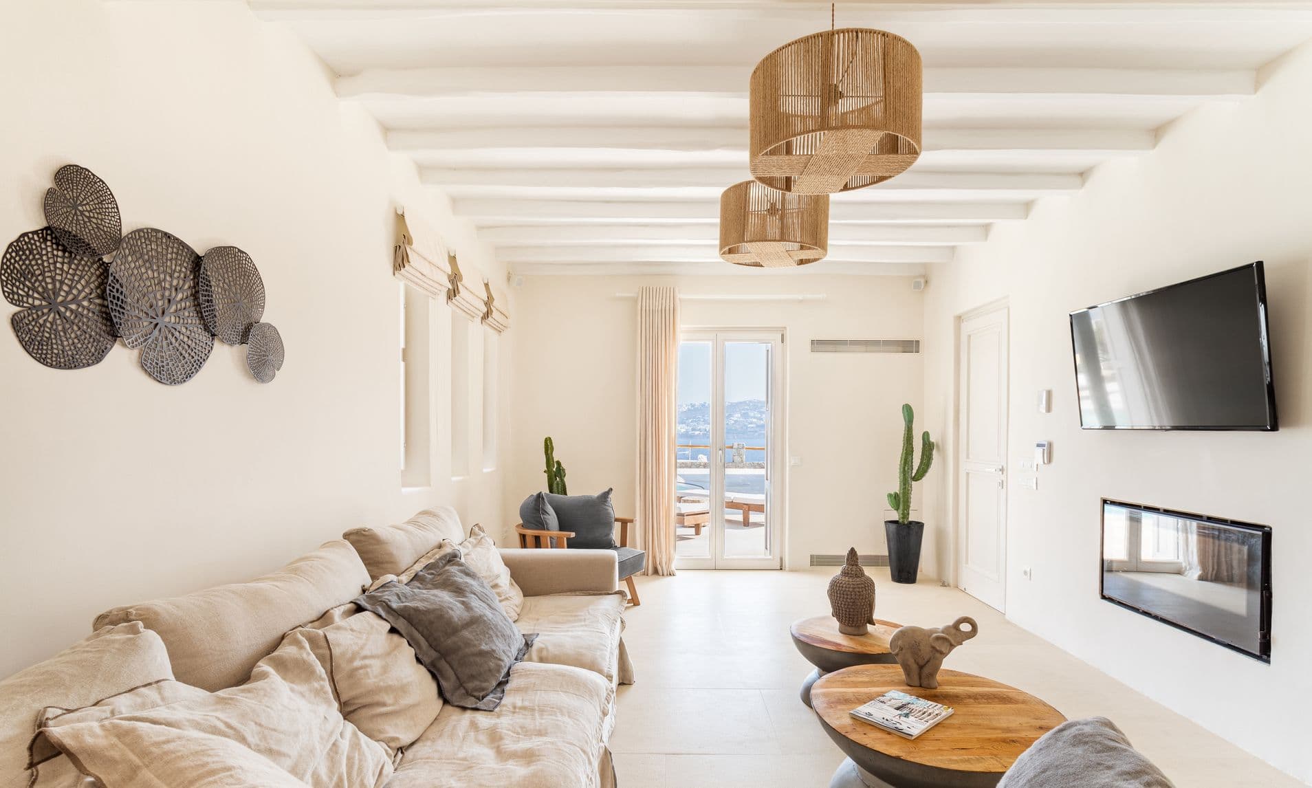 Living area with corner fireplace, cream sofas and beamed white ceiling