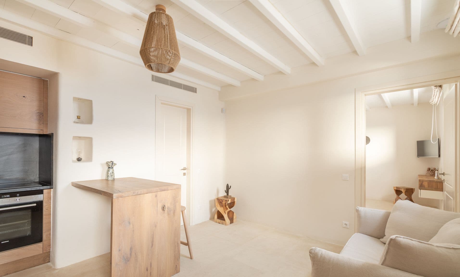 Snug seating nook with armchairs beneath a beamed white ceiling