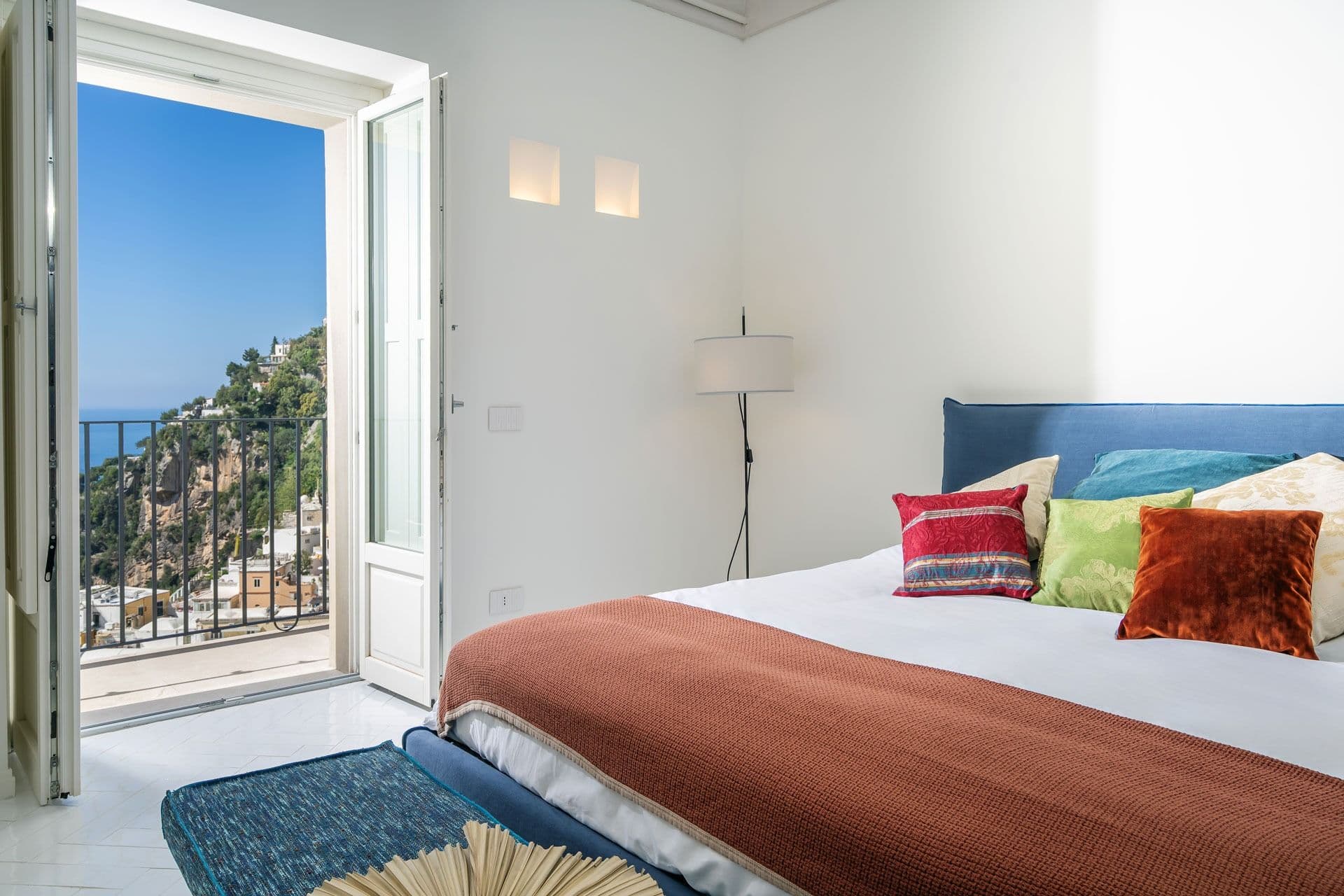 Bedroom with terracotta linen and sea-view balcony doors at Ocean House, Positano