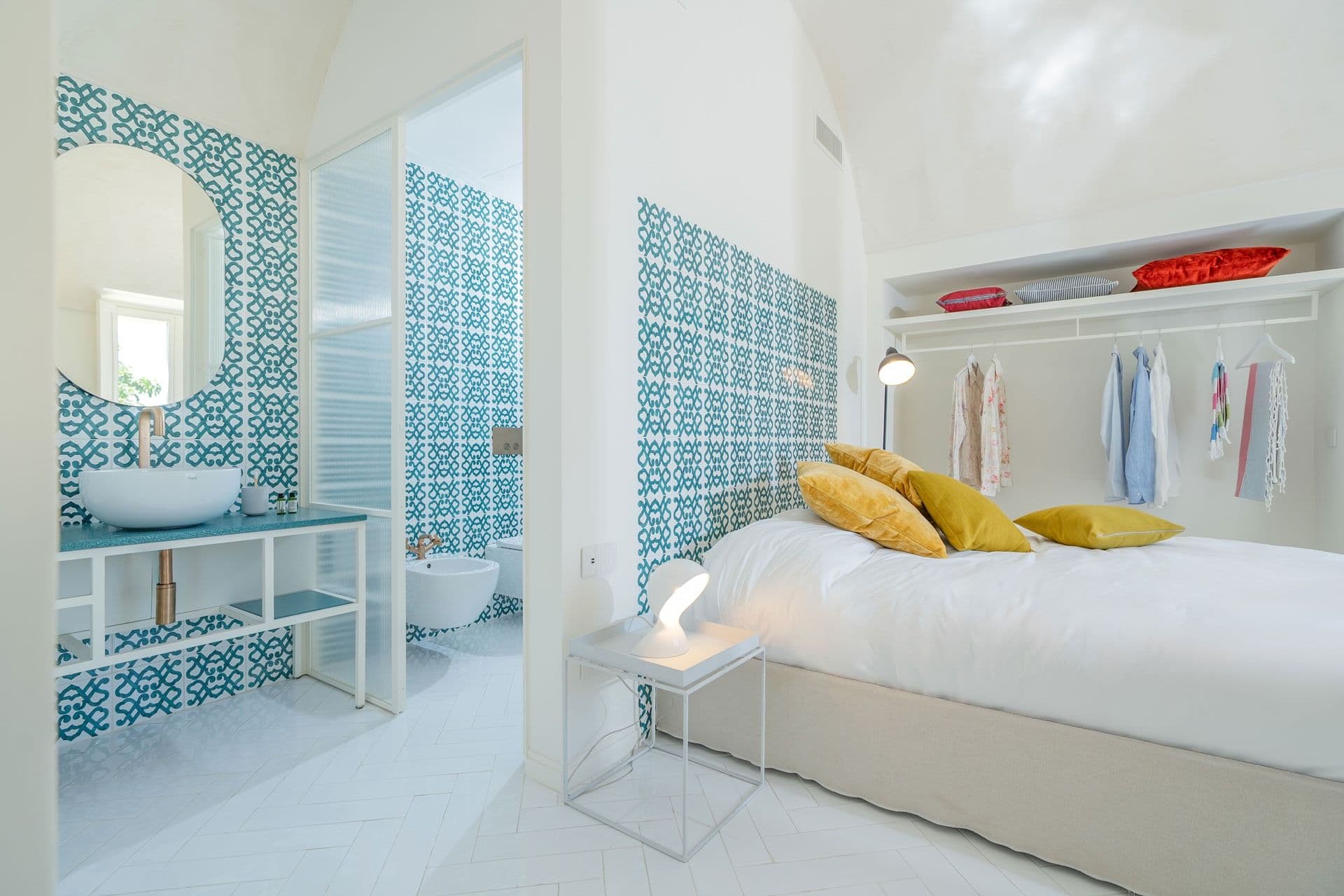 Bedroom with adjoining teal-tiled en-suite at Ocean House, Positano