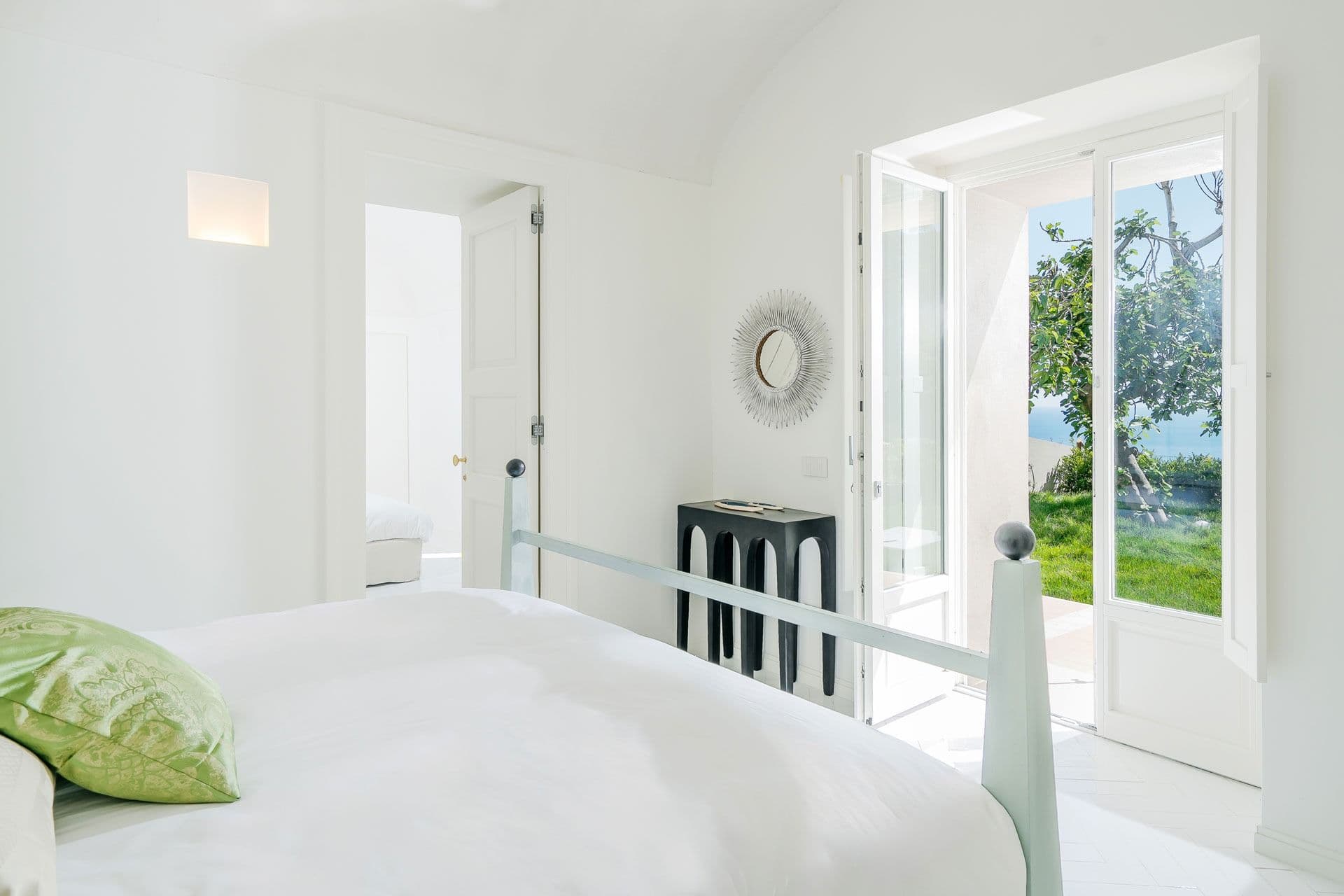 Bedroom with French doors opening onto the garden at Ocean House, Positano